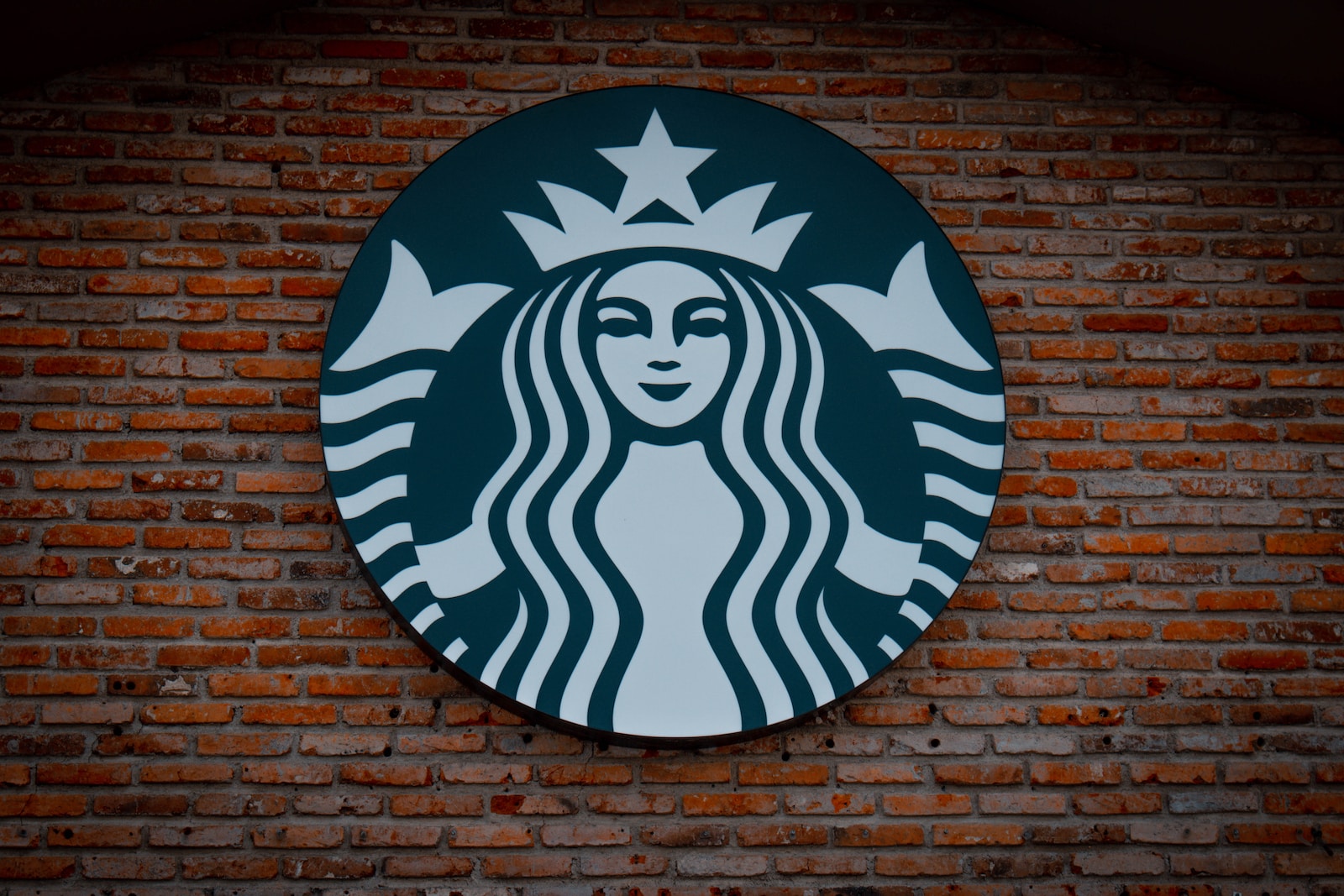 Starbucks logo signage on brown brick wall